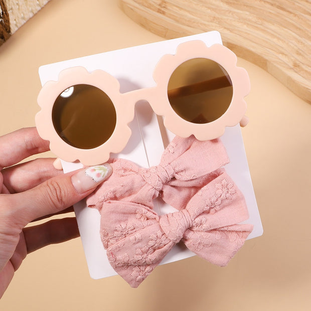 An accessory set for girls includes 2 hair clips and sunglasses