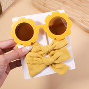 An accessory set for girls includes 2 hair clips and sunglasses