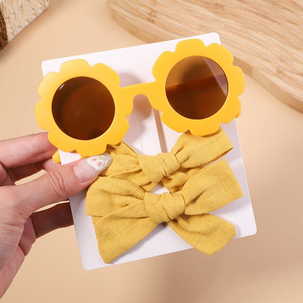 An accessory set for girls includes 2 hair clips and sunglasses