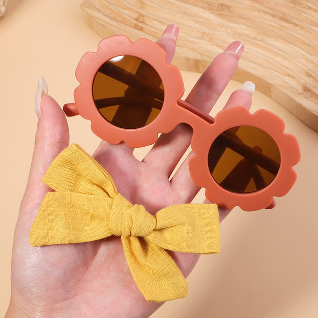 An accessory set for girls includes 2 hair clips and sunglasses