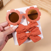 An accessory set for girls includes 2 hair clips and sunglasses