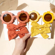 An accessory set for girls includes 2 hair clips and sunglasses